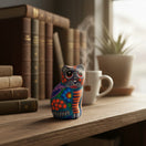 The Talavera Hub hand-painted ceramic cat figurine with vibrant Mexican folk art floral patterns on a wooden desk.