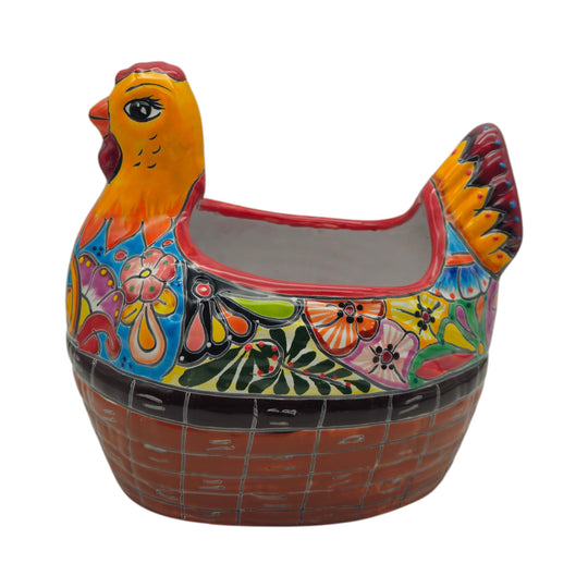 The Talavera Hub hand-painted Mexican ceramic chicken planter with vibrant floral patterns and a basket-weave base.