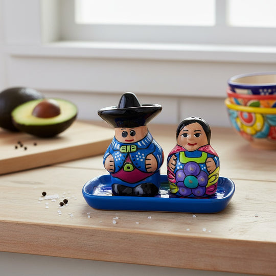 The Talavera Hub hand-painted ceramic salt and pepper shakers featuring a couple on a blue tray in vibrant colors.