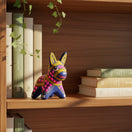 The Talavera Hub hand-painted ceramic donkey figurine with vibrant multicolor folk art patterns on a wooden bookshelf.