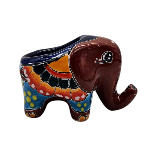 The Talavera Hub hand-painted ceramic elephant planter in vibrant red, yellow, green, and blue floral patterns.