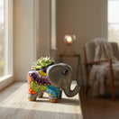 The Talavera Hub hand-painted ceramic elephant planter with colorful floral patterns holding a small green succulent.