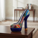 The Talavera Hub handcrafted ceramic high heel statue featuring vibrant multicolor floral patterns on a blue base.
