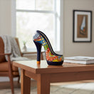 The Talavera Hub handmade ceramic high heel statue featuring vibrant hand-painted floral patterns on a wooden table.