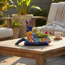 The Talavera Hub handcrafted ceramic horse planter with vibrant hand-painted floral patterns on a wooden patio table.