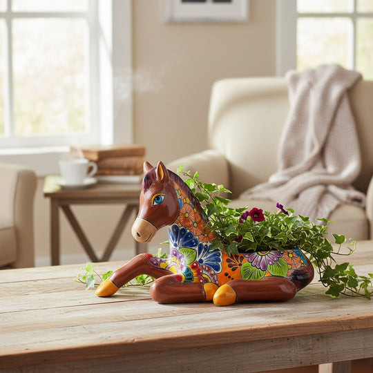 The Talavera Hub handcrafted ceramic horse planter with vibrant hand-painted floral patterns on a wooden table.