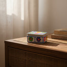 The Talavera Hub hand-painted ceramic Guerrero jewelry box with colorful floral patterns on a wooden dresser.