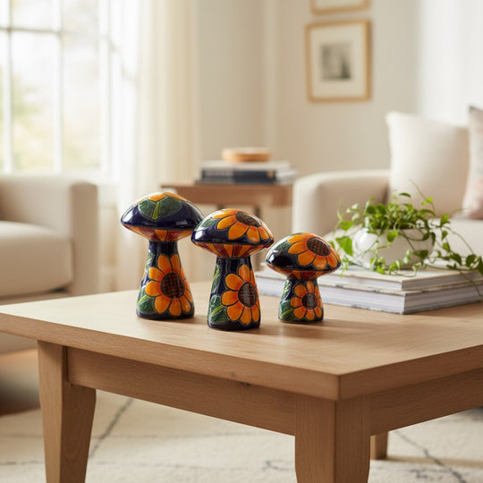 The Talavera Hub set of 3 ceramic mushrooms, hand-painted with sunflowers and green leaves on a dark blue background.