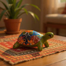 The Talavera Hub hand-painted ceramic sea turtle statue with vibrant Mexican folk art patterns on a patterned rug.