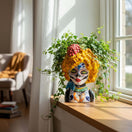 The Talavera Hub hand-painted ceramic lady skull planter with yellow hair and floral accents on a sunny windowsill.