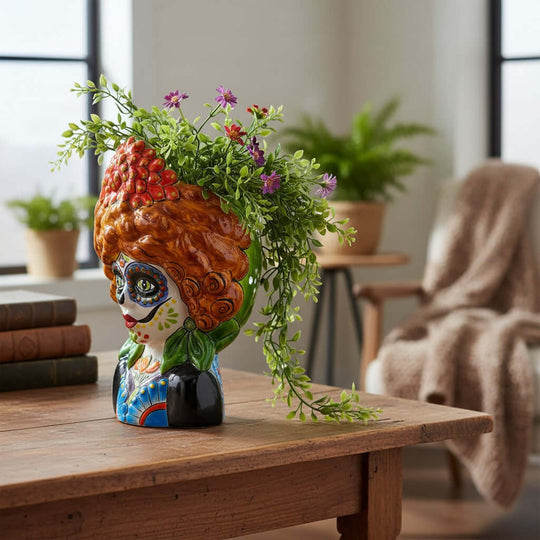 The Talavera Hub hand-painted ceramic lady skull planter with vibrant floral details and yellow hair on a wooden table.
