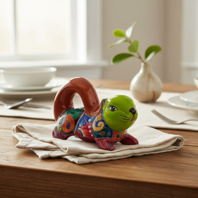 The Talavera Hub hand-painted ceramic squirrel statue with vibrant floral patterns and a glossy finish on a table.