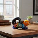 The Talavera Hub hand-painted ceramic squirrel statue with vibrant floral patterns and a glossy finish on a wooden desk.