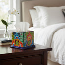 The Talavera Hub hand-painted ceramic tissue box cover with vibrant floral patterns on a wooden bedside table.