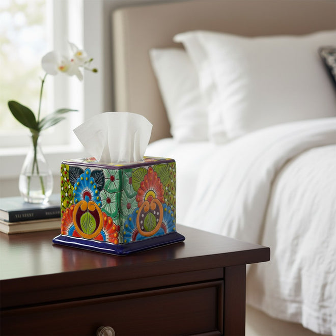 The Talavera Hub hand-painted ceramic tissue box cover with vibrant floral patterns on a wooden bedside table.