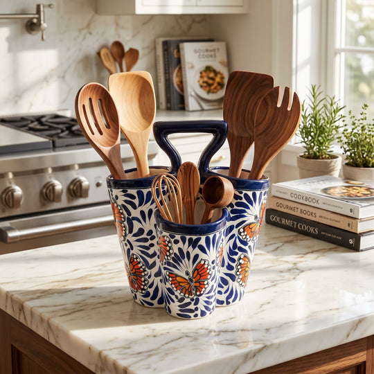 The Talavera Hub handmade ceramic utensil holder with blue and white butterfly design on a marble kitchen countertop.