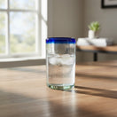 The Talavera Hub hand-blown clear glass tumbler with a cobalt blue rim, 5" tall, perfect for everyday use.