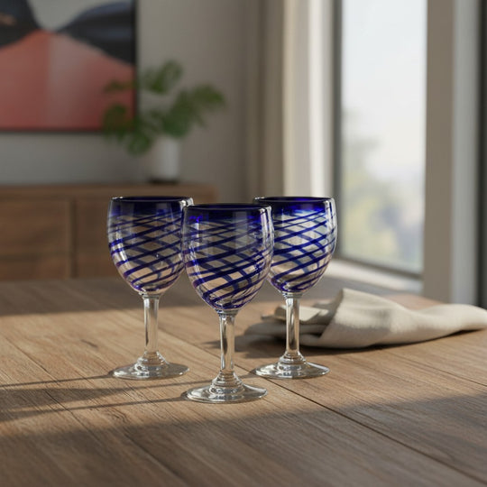 The Talavera Hub hand-blown Mexican wine glasses with cobalt blue swirls. Clear recycled glass, 12 oz capacity.