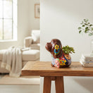 The Talavera Hub medium brown Talavera dog statue with colorful floral and geometric patterns. Hand-painted ceramic.