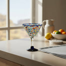 The Talavera Hub hand-blown glass martini glass with confetti pattern and blue rim and base. Holds 12 oz.