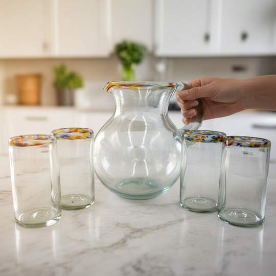 The Talavera Hub clear hand-blown glass pitcher with a confetti rim and matching glasses. Perfect for serving beverages.