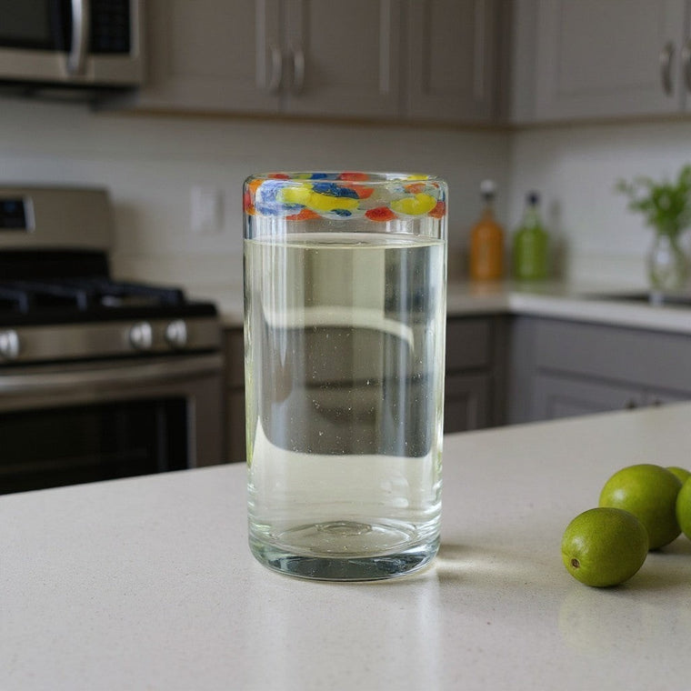 The Talavera Hub hand-blown glass tumbler with a clear body and a colorful confetti rim. Ideal for everyday use or festive occasions.