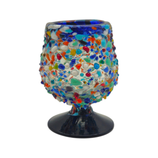 The Talavera Hub confetti rock shot glass with blue rim and pedestal base, made of lead-free glass.