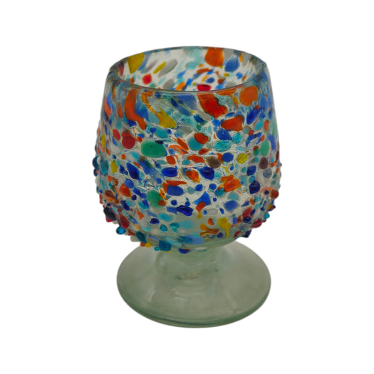 The Talavera Hub confetti rock shot glass, handcrafted from clear recycled glass with colorful fused glass beads. Features a pedestal base.