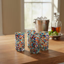 The Talavera Hub hand blown double shot glasses with colorful confetti pattern, made of clear glass.