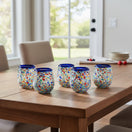 The Talavera Hub hand-blown stemless wine glass with blue rim and colorful confetti pattern, 12 oz capacity