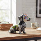 The Talavera Hub black ceramic dachshund figurine with Day of the Dead floral and skeletal motifs, hand-painted glaze.