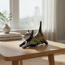 The Talavera Hub black ceramic cat statue with Day of the Dead floral design in yellow, purple, and red. Features skeletal details.