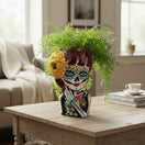 The Talavera Hub handmade ceramic Day of the Dead face planter, hand-painted with floral patterns and a yellow flower.