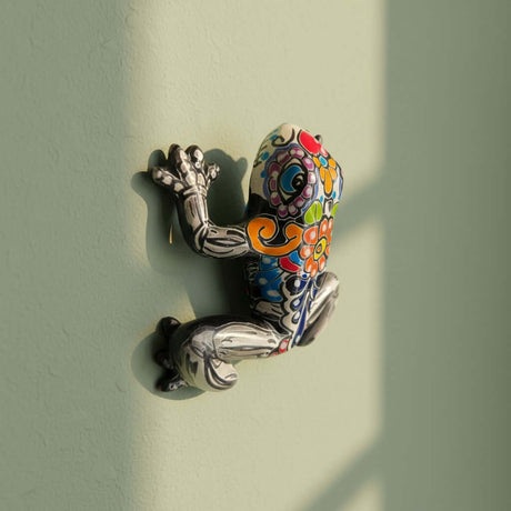 The Talavera Hub black ceramic frog figurine with colorful floral and skull motifs, Day of the Dead art, 7" long.