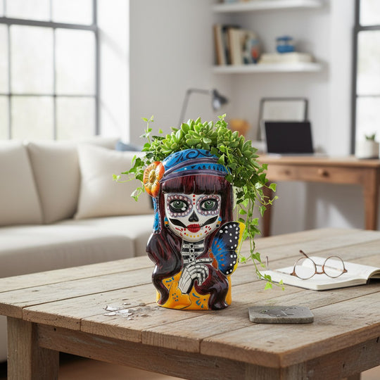 The Talavera Hub Day of the Dead skull planter with butterfly and floral accents, hand-painted ceramic in orange, blue, and purple.