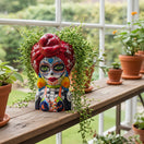 The Talavera Hub lady skull planter with red headscarf, intricate face paint, and colorful Day of the Dead design. Ceramic.