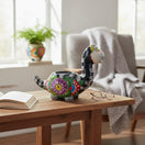 The Talavera Hub black ceramic brachiosaurus planter with colorful floral and skull motifs, 8" tall.
