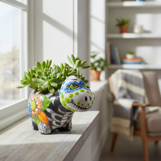 The Talavera Hub black ceramic brachiosaurus planter with Day of the Dead skull face, floral motifs, and green polka dots.