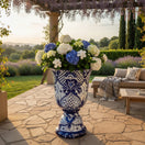 The Talavera Hub extra large blue and white hand-painted Talavera pedestal planter with intricate floral details, filled with hydrangeas.
