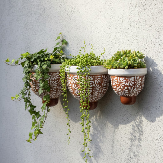 The Talavera Hub set of 3 handcrafted brown and white floral ceramic wall planters with trailing succulents