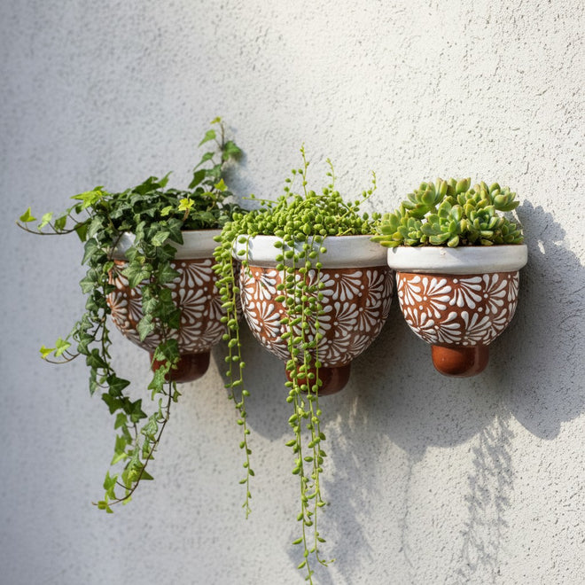 The Talavera Hub set of 3 handcrafted brown and white floral ceramic wall planters with trailing succulents