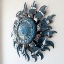 The Talavera Hub Giant Sun Wall Art, handmade Mexican metalwork with blue face and radiant rays, includes light fixture.