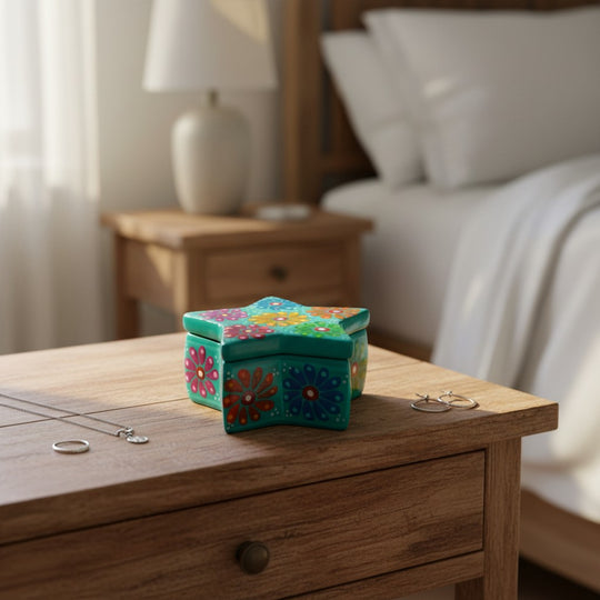 The Talavera Hub Guerrero star-shaped ceramic jewelry box with vibrant hand-painted floral motifs on a wooden nightstand