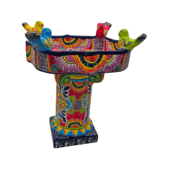 The Talavera Hub hand-painted ceramic bird bath with vibrant floral patterns and colorful perched bird accents.