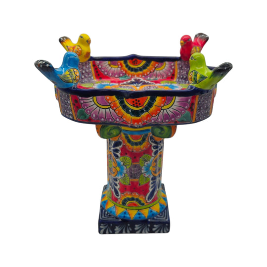 The Talavera Hub hand-painted ceramic bird bath with vibrant floral patterns and perched birds in pink, blue, and green