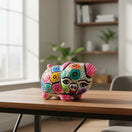 The Talavera Hub handmade ceramic piggy bank with vibrant hand-painted floral and geometric patterns on a wooden table
