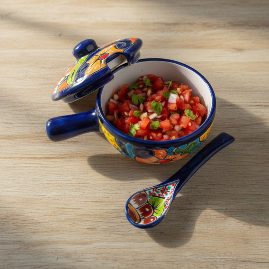 The Talavera Hub hand-painted ceramic salsa bowl with lid and spoon, featuring multicolor floral and geometric patterns.