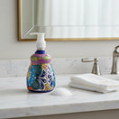 The Talavera Hub handcrafted ceramic soap dispenser with vibrant multicolor floral patterns on a marble bathroom vanity