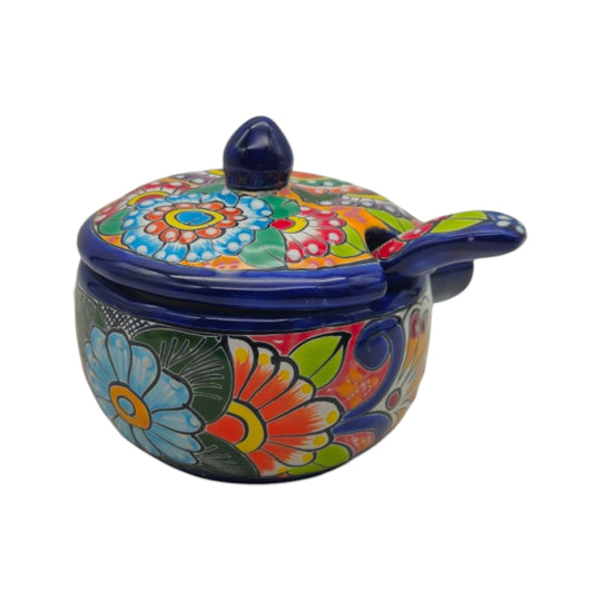 The Talavera Hub hand-painted ceramic soup bowl with lid and matching spoon featuring vibrant floral Mexican patterns.