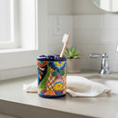The Talavera Hub handcrafted ceramic toothbrush holder with vibrant Mexican folk art patterns and a cobalt blue rim.